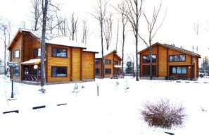 Traditional cabins with large windows and front porches.