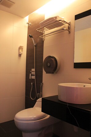 A modern bathroom with a toilet, a sink, a towel rack, a shower head, and a hand dryer. - Time Hotel Kuchai Lama (Kuala Lumpur)