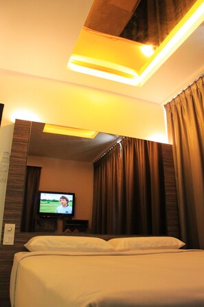 A hotel room with a bed, a television on the wall, and a ceiling light fixture. - Time Hotel Kuchai Lama (Kuala Lumpur)