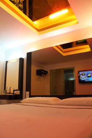 A modern hotel room with a large bed, a flat-screen TV mounted on the wall, and a ceiling light fixture. - Time Hotel Kuchai Lama (Kuala Lumpur)