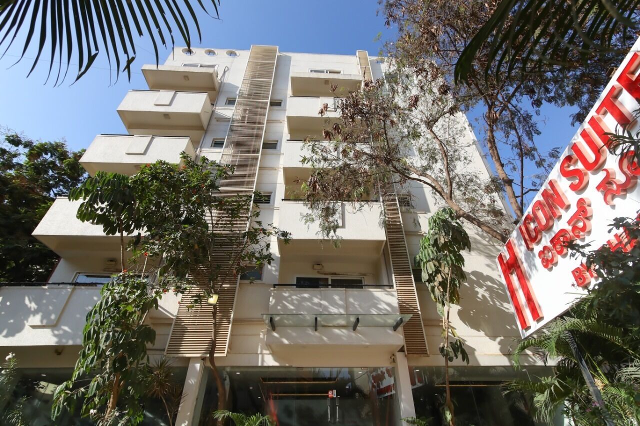 A multi-story hotel with a modern design, featuring balconies and a prominent signboard.