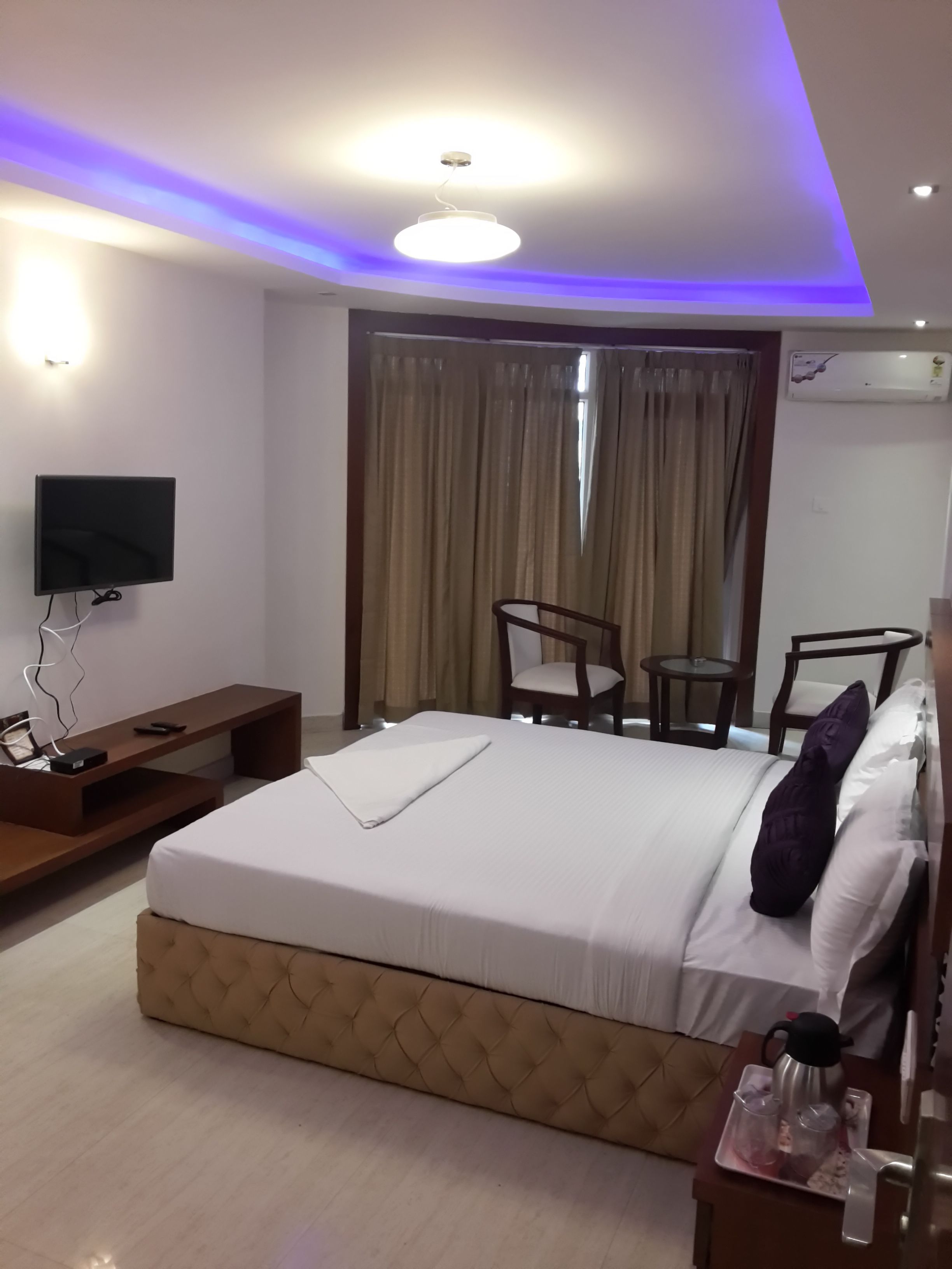 Una habitación de hotel con cama, televisión, escritorio y silla.