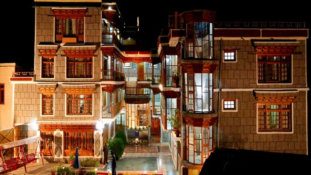 A multi-story building with balconies, a courtyard, and outdoor seating.