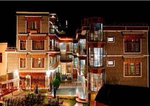 A multi-story building with balconies, a courtyard, and outdoor seating.