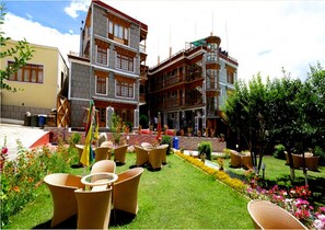 A hotel with a garden area featuring outdoor seating and potted plants.