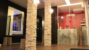 A lobby with stone pillars, a reception desk, and a large window. - Time Hotel Sunway (Petaling Jaya)