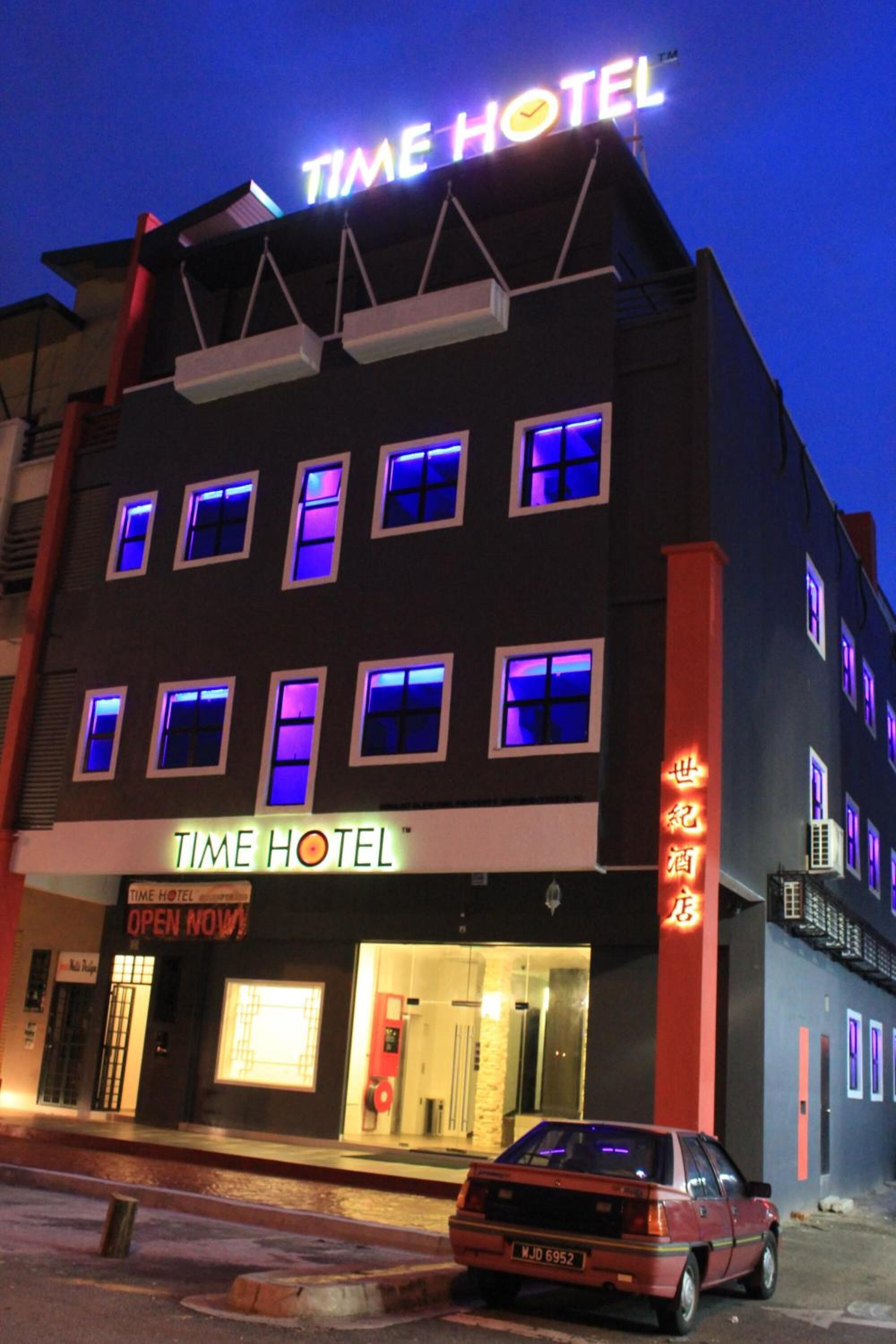 Um hotel com uma placa que diz “TIME HOTEL” e “ABERTO AGORA”.