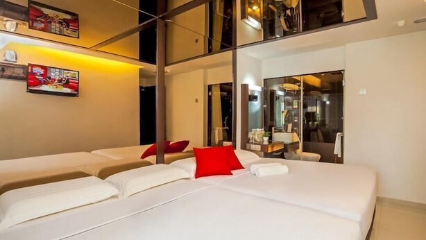 A modern hotel room with a large bed, a red pillow, and a glass partition separating the room from the bathroom. - Time Hotel Sunway (Petaling Jaya)
