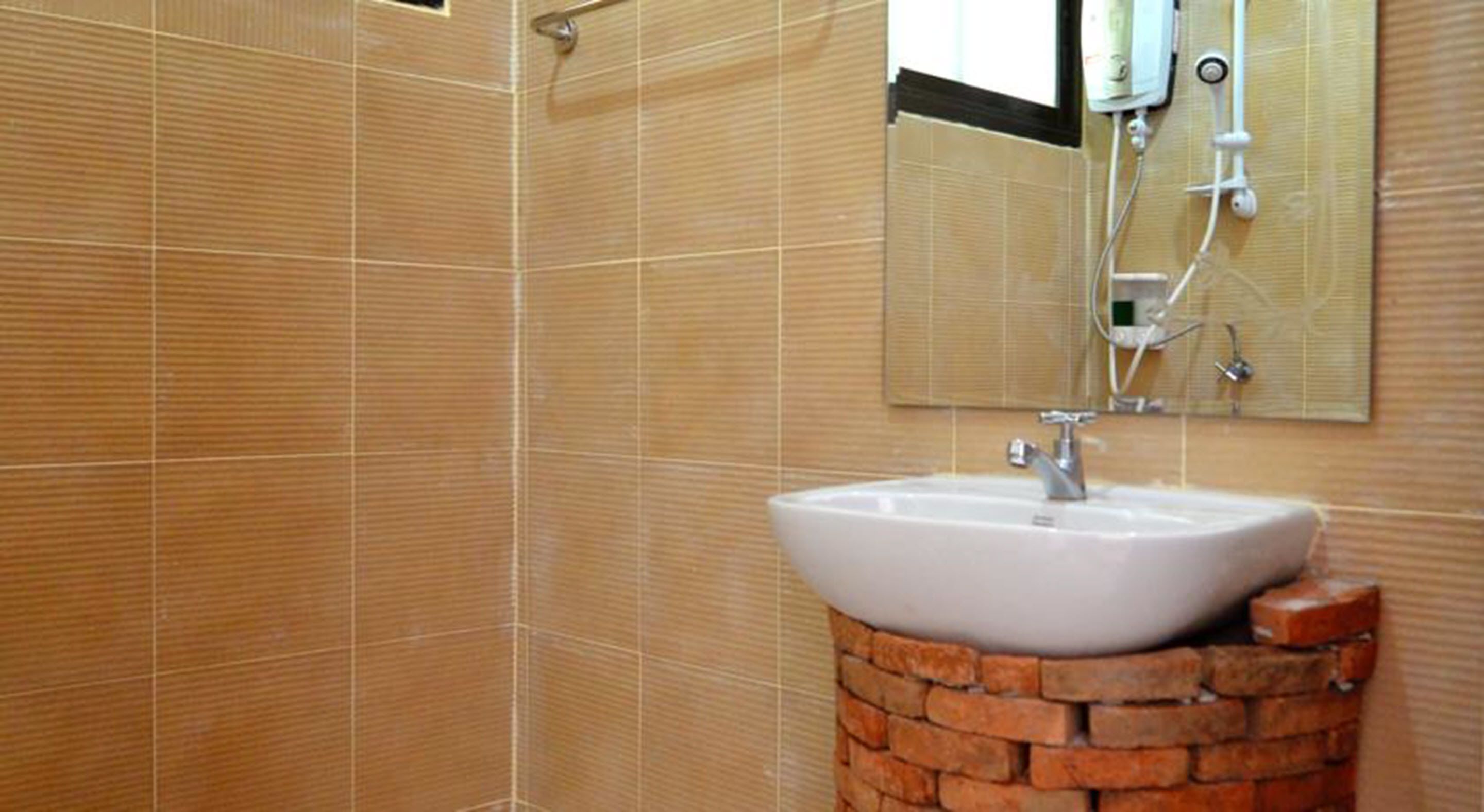 A bathroom with a white sink, a mirror, and tiled walls.