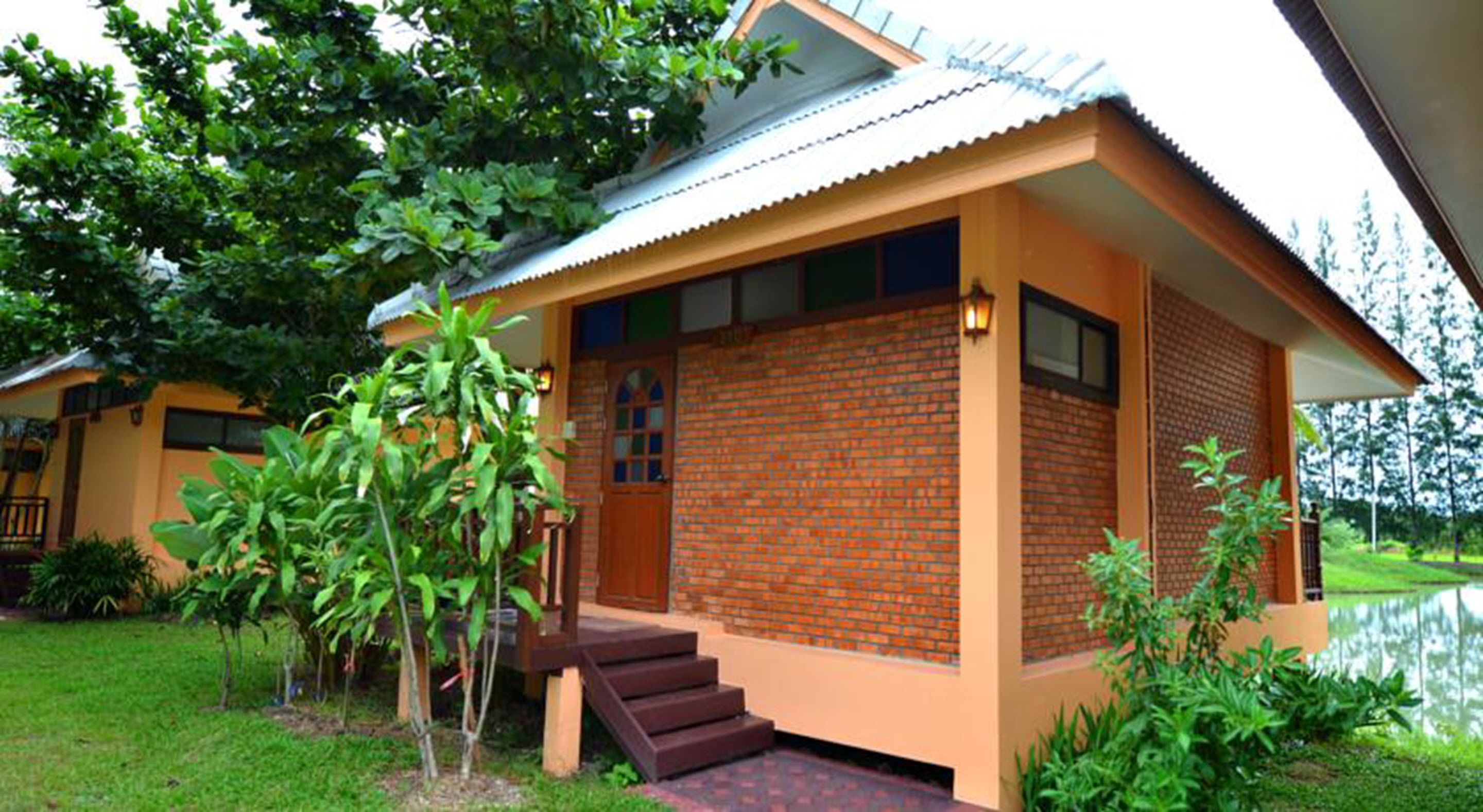 A bungalow with a brick exterior, a porch, and a small garden area.