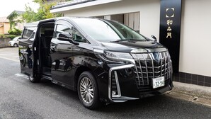 A black van parked in front of a building with a black and gold sign. - Ryokan Nagomitsuki (Beppu)