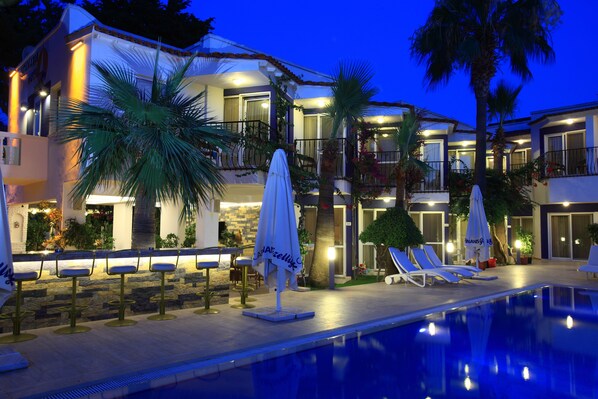 Una piscina al aire libre de temporada, sombrillas