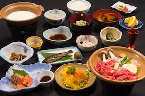 Une variété de plats, notamment des sushis, des sashimis et d’autres spécialités de la cuisine japonaise, présentés sur une table.