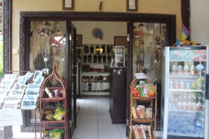 Una tienda con postales, aperitivos y una nevera llena de bebidas.