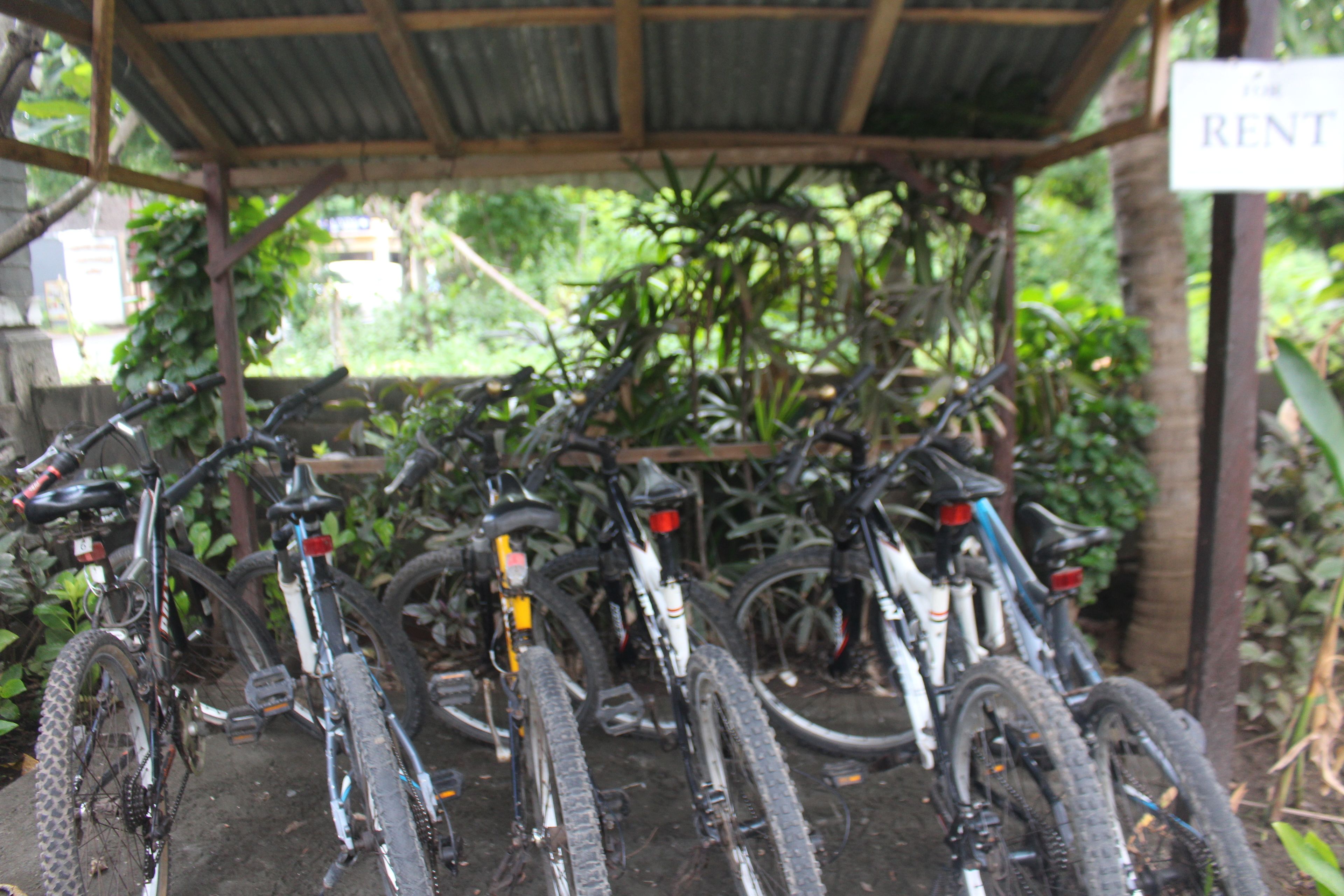 Uma área de estacionamento coberta para bicicletas, com várias bicicletas.