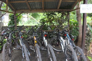Uma área de estacionamento coberta para bicicletas, com várias bicicletas.