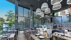 An outdoor dining area with wicker chairs and tables, a buffet setup, and hanging wicker light fixtures. - Villa Sonata Phuket (Chalong)