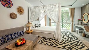 A modern hotel room with a bed, a sofa, a desk, and a fruit bowl. - Villa Sonata Phuket (Chalong)