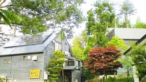 A rustic building with a sloped roof, a small porch, and a signboard. - Pension Good Luck Takayama (Takayama)