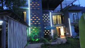 A modern building with a unique facade featuring illuminated windows and a rooftop garden. - Hotel Villa del Mar (Batumi)