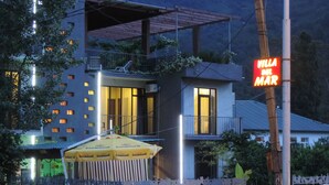 A modern building with a balcony, a sign reading "Villa del Mar", and a yellow umbrella in front. - Hotel Villa del Mar (Batumi)