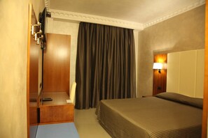 A hotel room with a bed, a desk, a lamp, and a curtain. - B&B Federica's House in Rome (Rome)
