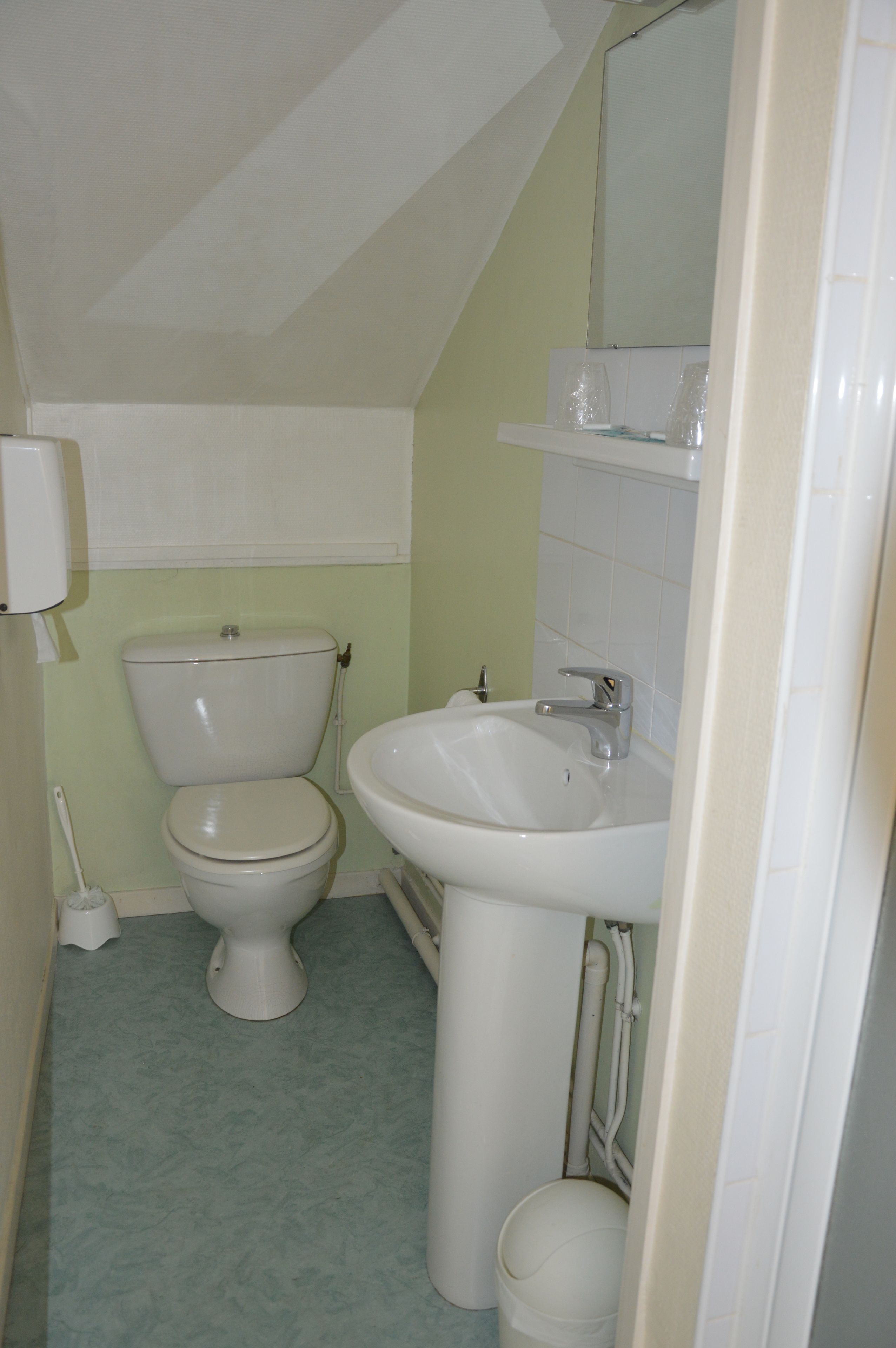 Un baño pequeño con inodoro, lavabo y espejo.