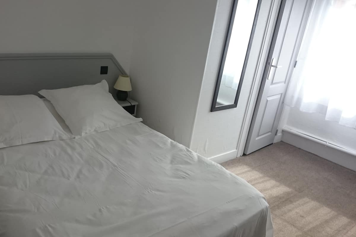 Una cama bien hecha con ropa blanca en una habitación de hotel.