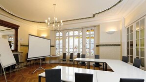 A conference room with a large oval table, whiteboard, and chairs. - Hôtel de Normandie (Amiens)