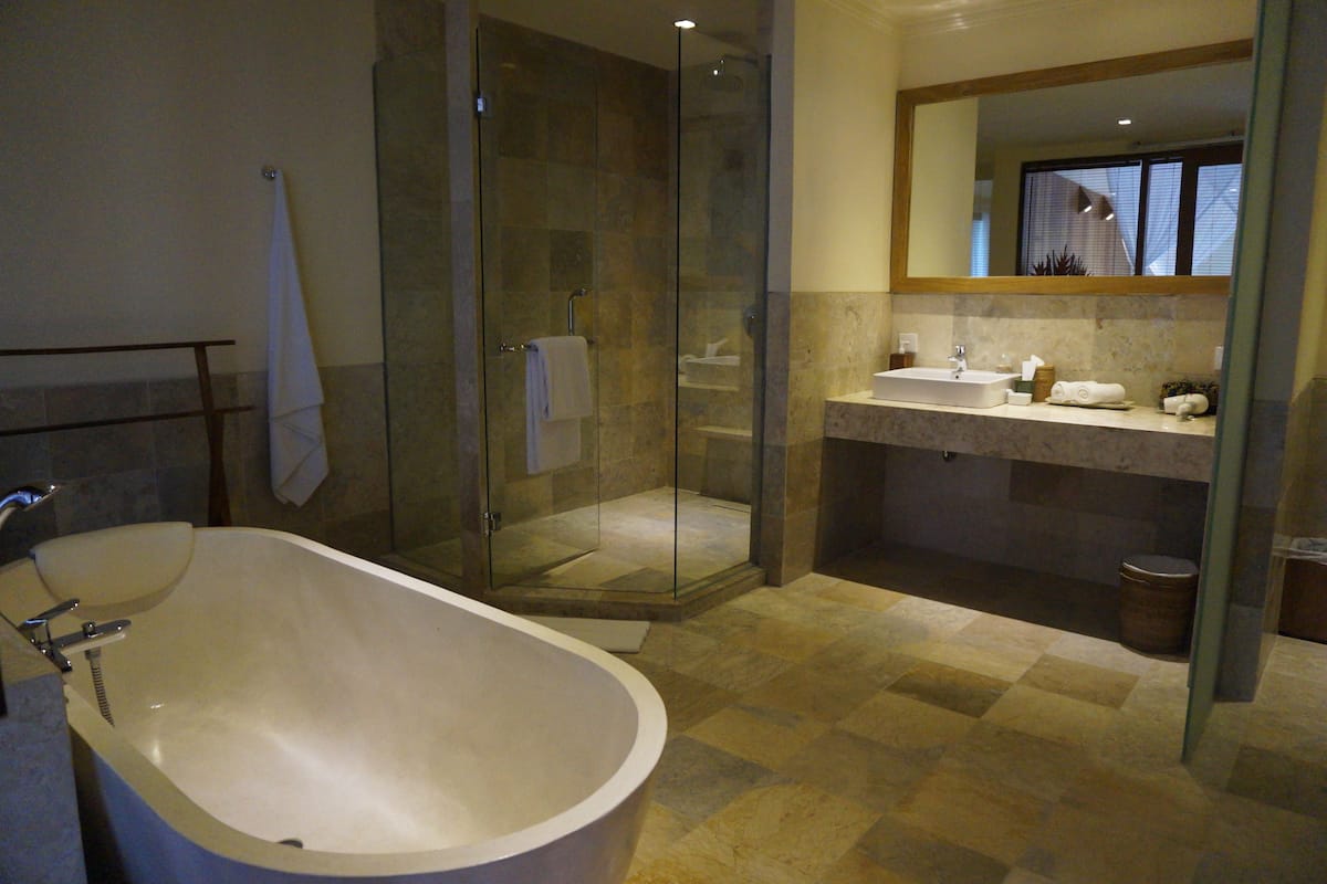 A modern bathroom with a freestanding bathtub, a glass-enclosed shower, and a vanity with a mirror.