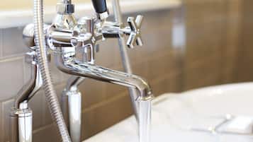 Un baño moderno con grifo y ducha de cromo, cabezal de ducha y bañera.