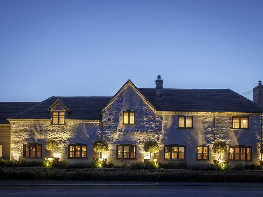A stone building with multiple windows and a chimney, labeled "Hurley House Hotel."