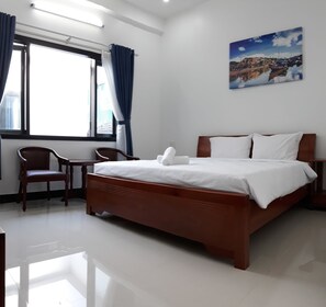 Un dormitorio con una cama de madera, un escritorio y una silla.