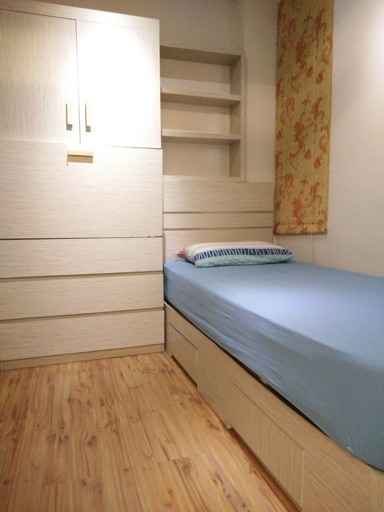 Une chambre à coucher avec un lit, une armoire en bois et des étagères intégrées.