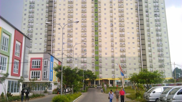 Ein mehrstöckiges Hotel mit zentralem Eingang, Balkonen und einem Schild mit der Aufschrift 'the SUITES'.