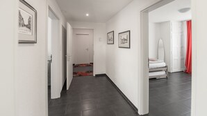 Un pasillo con una cama, un espejo y cuadros en las paredes.