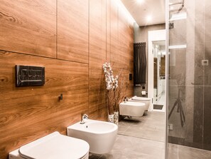 Suite | Badkamer | Een douche, een haardroger, handdoeken, toiletpapier