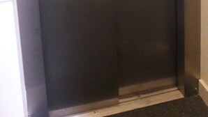 Un ascenseur métallique doté d’un panneau de commande situé sur le côté droit.