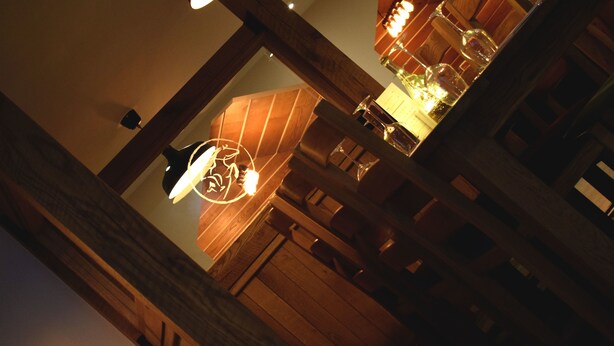 A wooden interior with a hanging light fixture and a wooden bench. - The Horse & Jockey Wessington (Alfreton)