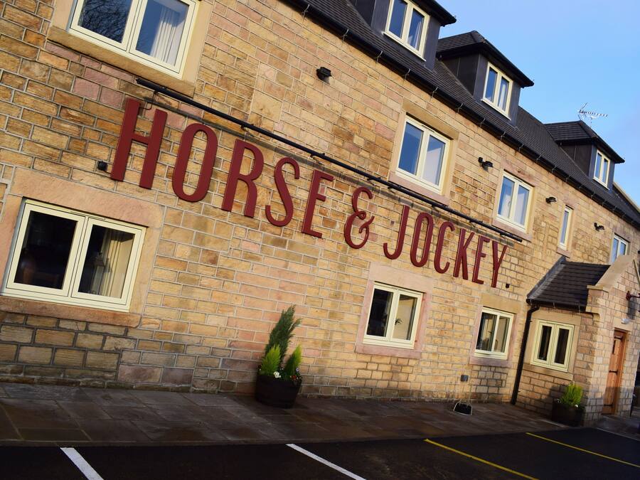 Un edificio con un letrero que dice "HORSE & JOCKEY".