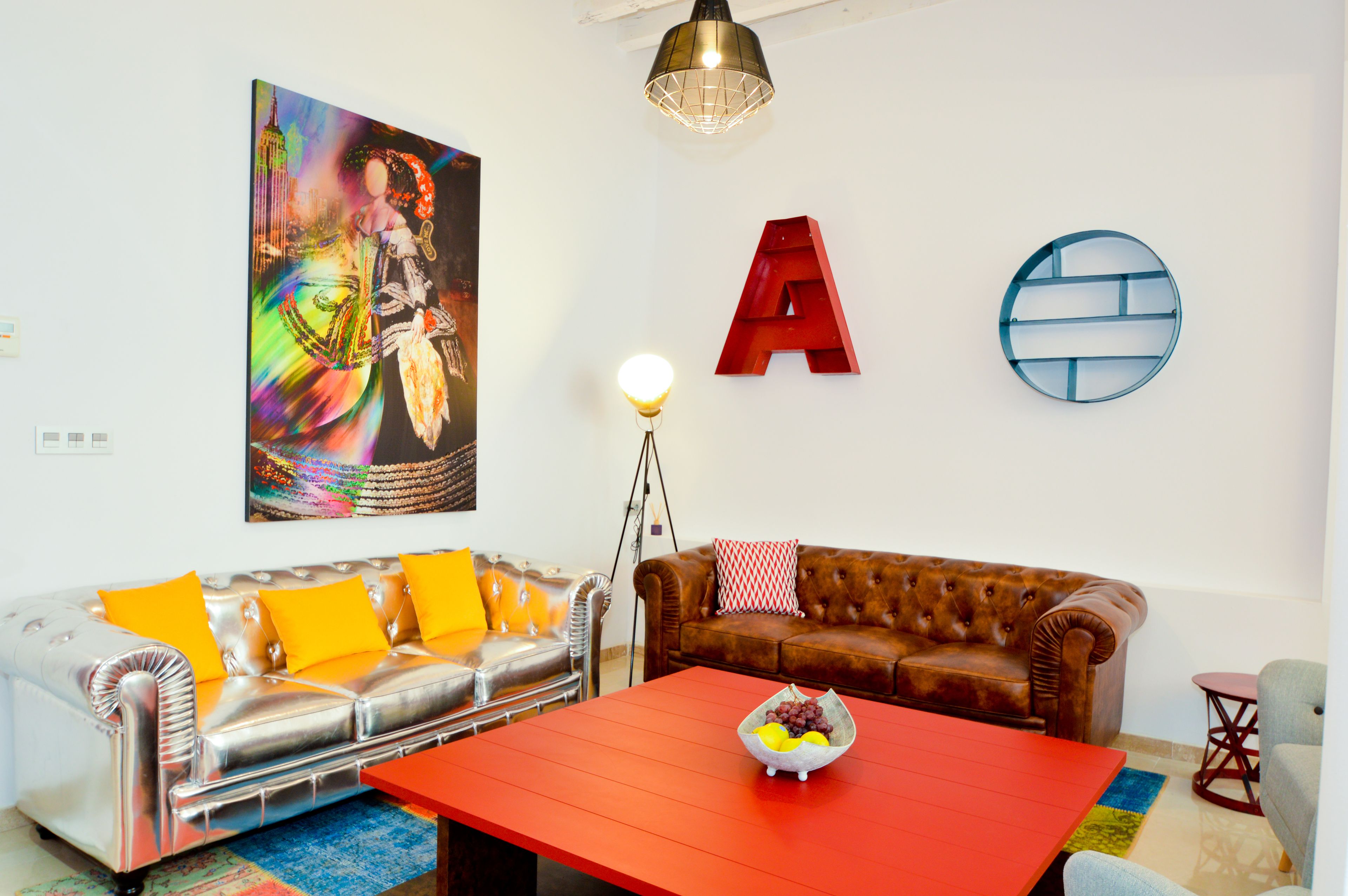 Una sala de estar con un sofá, una mesa de centro y una lámpara.