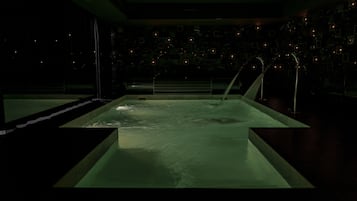 Relax by the serene, rectangular pool surrounded by ambient lighting and a dark, reflective floor.