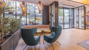 A modern interior with a seating area, large windows, and indoor plants. - Hotel Soho Boutique Granada (Granada)