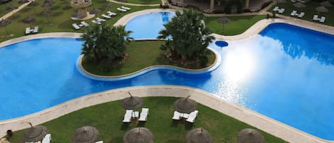 Piscine couverte, piscine extérieure, parasols de plage, chaises longues