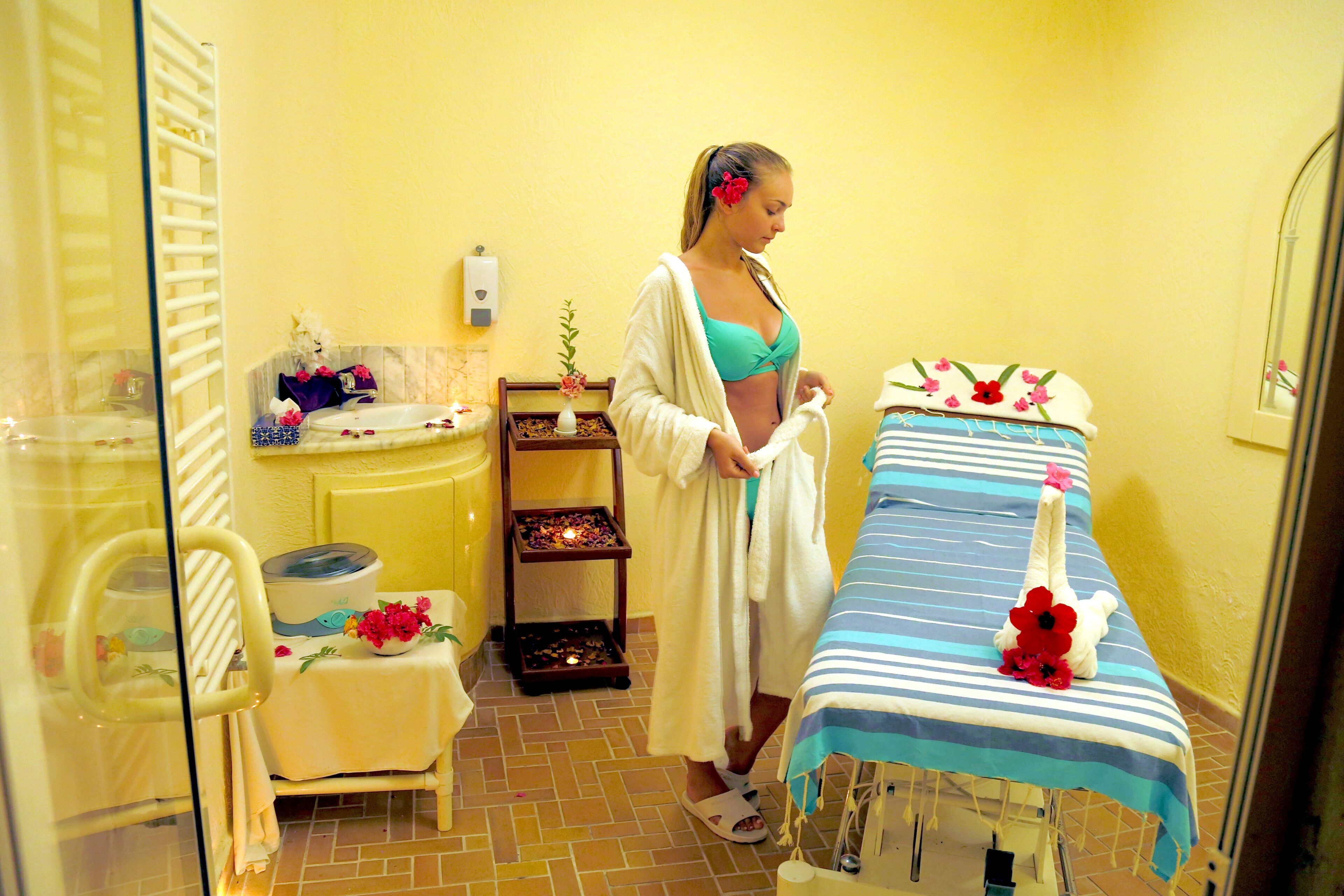 A bathroom with a bathtub, a sink, a towel rack, and a shelf with toiletries.