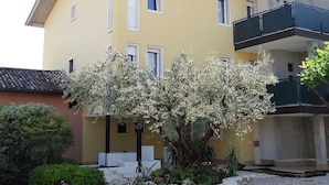 Un edificio a due piani con facciata gialla, finestre bianche e un balcone.