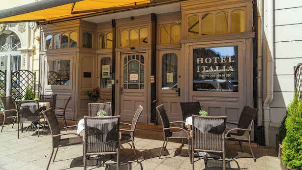 A hotel exterior with wicker chairs, a yellow awning, and a sign reading 'HOTEL ITALIA.' - Hotel Italia (Görlitz)