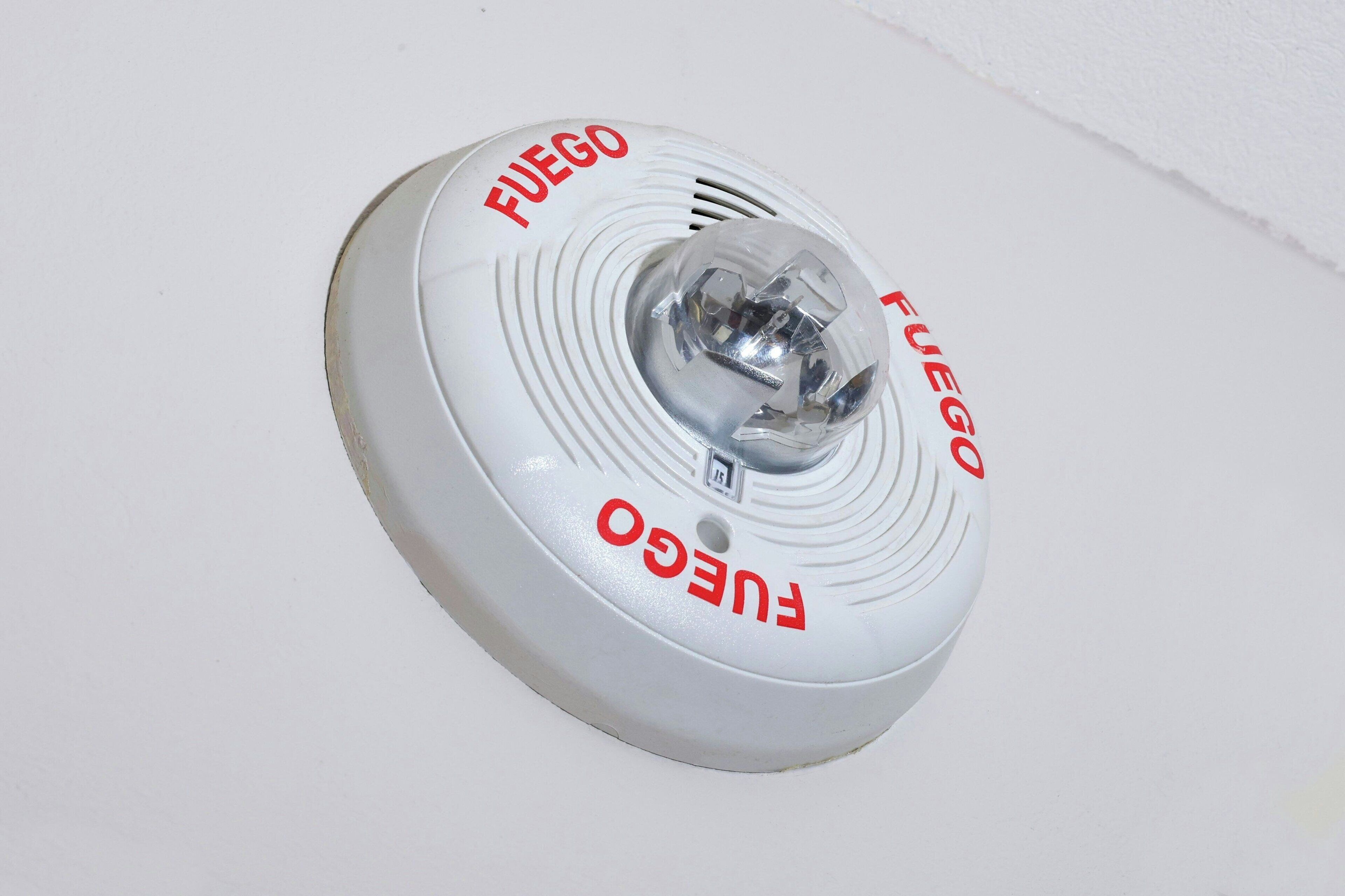 A white smoke detector with the brand name "FUEGO" on it.