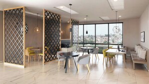 A modern dining area with a high ceiling, large windows, and a view of a cityscape.