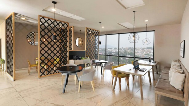 A modern dining area with a high ceiling, large windows, and a view of the city.